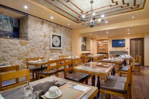 美特索文卡萨罗斯酒店的一间设有木桌和椅子的餐厅以及石墙