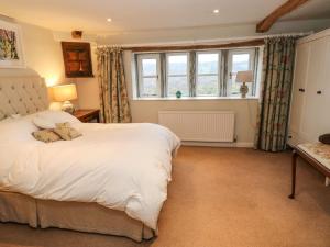 哈德斯菲尔德Woodlea Cottage的卧室设有一张白色大床和一扇窗户。