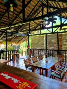 San MiguelBinga Beach Palawan Glamping的餐厅设有木桌、椅子和天花板