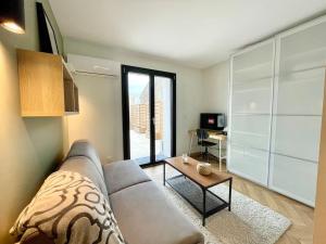 维勒班Le Flachet - Climatisation - Wifi的客厅配有沙发和桌子
