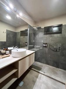 乌尼翁镇Tres Cruces的浴室配有水槽、淋浴和浴缸。
