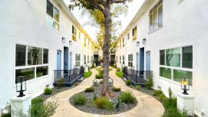 洛杉矶Kingsley Courtyard Apartment的两栋建筑中间有树的庭院