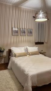 卡尔季察House in the Woods的卧室配有一张白色大床和吊灯。