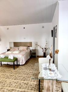科隆Posada Los Molles的一间卧室配有一张床、一张沙发和一张桌子