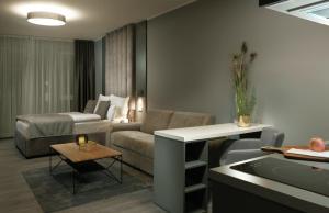 美因河畔法兰克福THE ROOMS - Hotel & House的客厅配有沙发和桌子