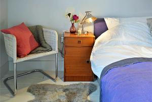 哈罗盖特皇家巡游公寓 的一间卧室配有一张床、一把椅子和一个床头柜
