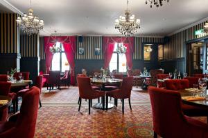 厄斯特松德贝斯特韦斯特老剧院酒店的用餐室配有桌椅和吊灯。