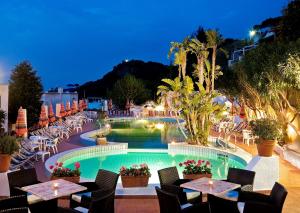 伊斯基亚Casa Di Meglio Dependance的一个带游泳池和桌椅的度假酒店
