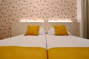 洛斯马蒂雷斯201 I Posada del Mar I Encantador hostel en la playa de Gandia的一间卧室配有两张带黄色枕头的床