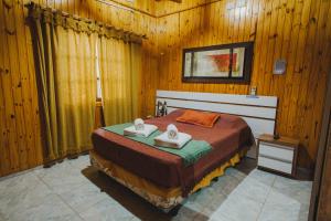 伊瓜苏港Cabañas Riberas del Paraná的一间卧室配有一张床,上面有两条毛巾