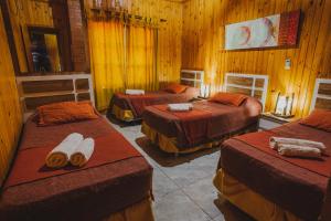 伊瓜苏港Cabañas Riberas del Paraná的木房里设有三张床的房间