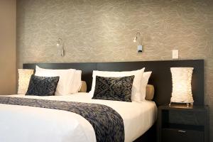 纳尔逊纳尔逊扬帆酒店的配有白色枕头的酒店客房内的两张床
