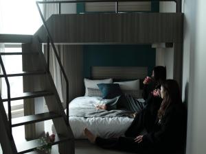 东京FAV TOKYO Nishinippori的两个女人坐在阁楼的床上