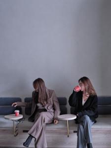 东京FAV TOKYO Nishinippori的坐在沙发上喝杯酒的两位妇女