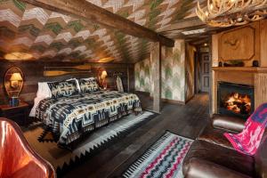 Big IndianUrban Cowboy Lodge的一间卧室配有一张床和一个壁炉