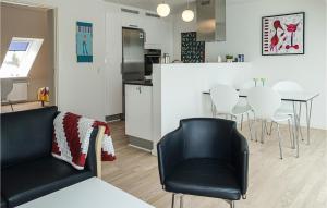 伦讷Amazing Apartment In Rnne With 2 Bedrooms And Wifi的厨房以及带桌椅的起居室。