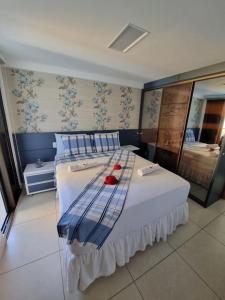 卡贝德卢Apartamento a beira mar com piscina estilo resort的卧室配有带蓝色枕头的大型白色床