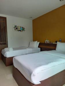 拉威海滩本加玛斯普雷斯酒店的一间酒店客房,房间内设有两张床