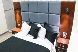 提华纳HOTEL MISION 11的一间卧室配有一张大床,提供黑白枕头