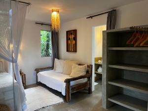 托兰克索Casa Viva Trancoso的卧室配有床、椅子和窗户。