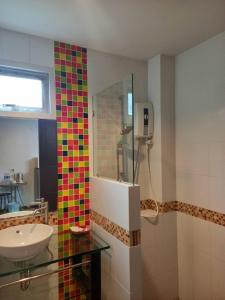 拉威海滩本加玛斯普雷斯酒店的浴室设有水槽和色彩缤纷的瓷砖淋浴。