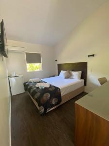 Moura煤炭与牛汽车旅馆的一间卧室设有一张大床和一个窗户。