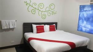 马尼拉Regal Residences的一间卧室配有一张带红色枕头的大床