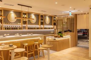 大园区CHO Stay Capsule Hotel-Taoyuan Airport T2的一间带酒吧和凳子的餐厅