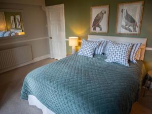 巴斯洛The Beeches - Chatsworth Apartment No 1 - Sleeps 2的一间卧室配有一张带蓝色棉被的大床