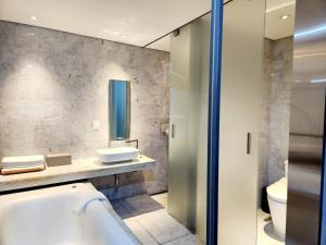 华城市JS精品酒店的带浴缸、盥洗盆和卫生间的浴室
