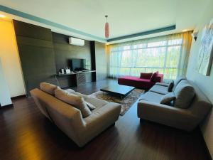 哥打京那巴鲁AA Residen Luxury Condo HOMESTAY 18mins walk Tanjung Aru Beach & GOLF Course, not Beach Side Resort的客厅配有沙发和两张沙发