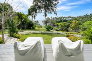 库德岛Shantaa Resort, Kohkood的天井上配有两把白色椅子,俯瞰着花园