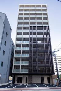 福冈Hotel Reference Tenjin III的一座高大的建筑,旁边设有阳台