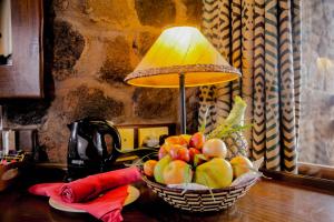 Tsavo凯丽古娜斯瑞娜狩猎山林小屋的桌上一篮水果和一盏灯