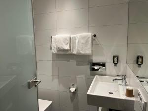 特里尔Hotel Römischer Kaiser的浴室配有盥洗盆、卫生间和毛巾。
