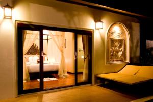 利巴诺伊Kanok Buri Resort的带1张床和1张沙发的卧室