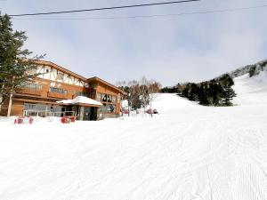 山之内町New Yokote的一座滑雪小屋,位于一座建筑前的雪覆盖的斜坡上