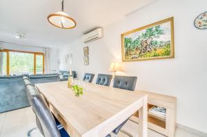 穆罗海滩Ideal Property Mallorca - Sirenas的一间带木桌和椅子的用餐室