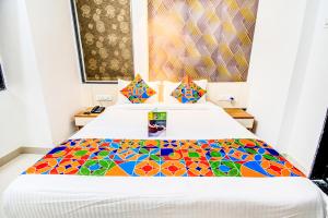 浦那FabExpress Marvel Bliss Viman Nagar的一间卧室配有一张带彩色床罩的床