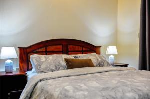 坎帕拉Eric Wilkins Apartments的一间卧室配有一张带两张台灯的床铺。