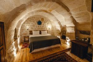 格雷梅Hanzade Cappadocia的卧室配有一张石墙床