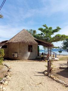 象岛The Tropical Beach Resort的一间有草屋顶的小小屋