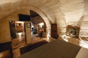 格雷梅Hanzade Cappadocia的一间设有石墙的房间和一张桌子