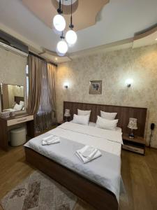 第比利斯萨纳皮罗第比利斯酒店的一间卧室配有一张大床和两条毛巾