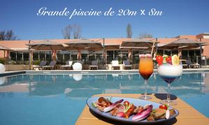 鲁塞Mount Venturi - Aix-En-Provence Sainte-Victoire - Bar & Restaurant & Padel的池畔餐桌上放着一盘食物和两杯饮料