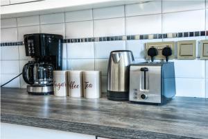 坎帕拉Eric Wilkins Apartments的厨房柜台配有咖啡机和咖啡壶