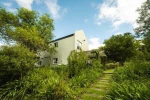 赫曼努斯Stonehaven Eco Cabins的被草地和树木环绕的白色房子