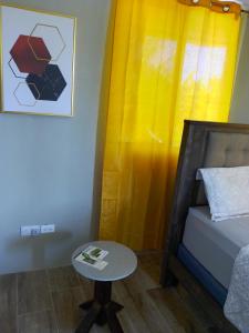Paix Bouche2 Bedroom Residential Rental Unit的一张小桌子,房间内设有床和黄色窗帘
