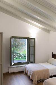 库迪列罗Casa Rural Monte Zarro的白色的客房设有两张床和窗户。