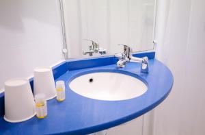 希利马扎兰Kyriad Direct Chilly-Mazarin的浴室设有蓝色水槽和镜子